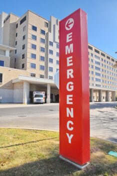 a red emergency sign in front of a large building